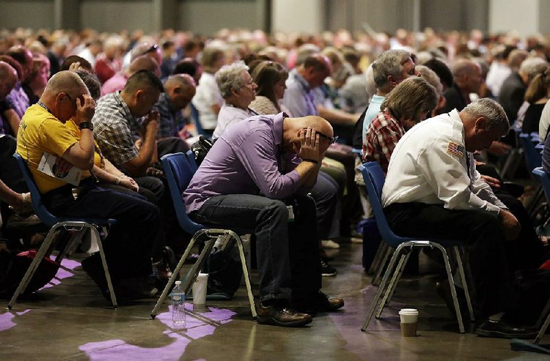 People pray Tuesday during the annual meeting of the Southern Baptist Convention in St. Louis. 