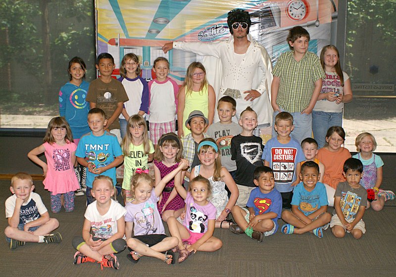 Photo by Randy Moll Participants in the summer reading program at Gentry Public Library June 8 posed for a photo with Elvis Presley (played by city employee Clint Osbourn). The focus of the June 8 session was again on life in the 1950s.