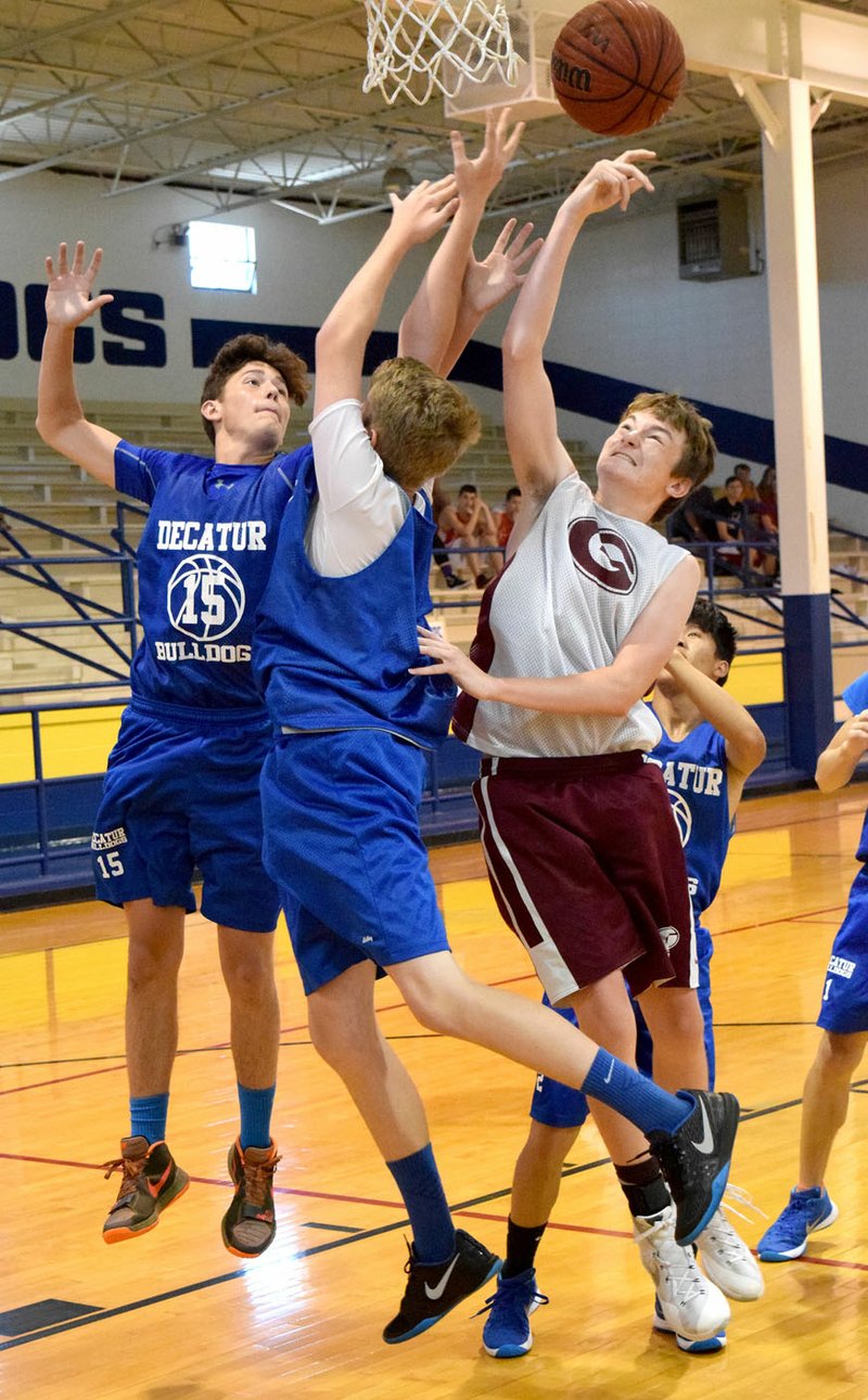 Photo by Mike Eckels Decatur&#8217;s Levi Newman (left) and Ryan Ross block a shot taken by Gentry&#8217;s Kyle Killgore during the Decatur Summer Classic basketball tournament at Peterson Gym in Decatur June 7. The two teams were evenly matched throughout the game, but it was Gentry that pulled out the victory, 20 to 18.