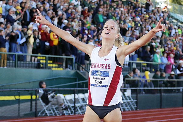 Arkansas' Dominique Scott points as she wins the women's 5,000 meters at the NCAA outdoor track and field championships in Eugene, Ore., Saturday, June 11, 2016. (AP Photo/Ryan Kang)