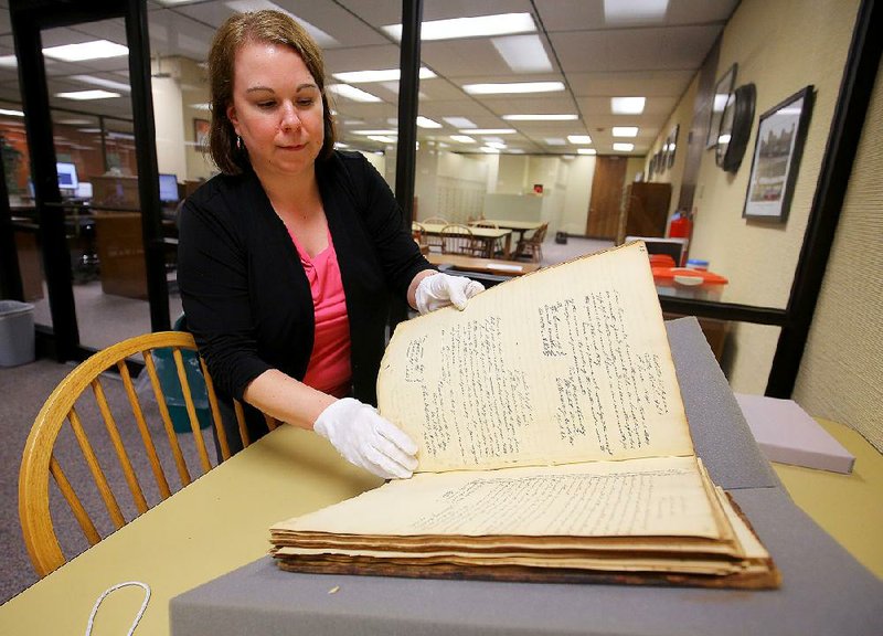 Danyelle McNeill, a digital archivist with the state archives, carefully opens a state auditor’s journal dating back to 1836. The journal was donated to the archives by Philip Palmer of Maumelle.