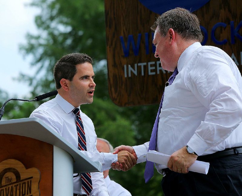 Warwick Sabin (left), executive director of the Arkansas Regional Innovation Hub, greets Winrock International President and CEO Rodney Ferguson on Wednesday. The two organizations announced that they are combining efforts. 