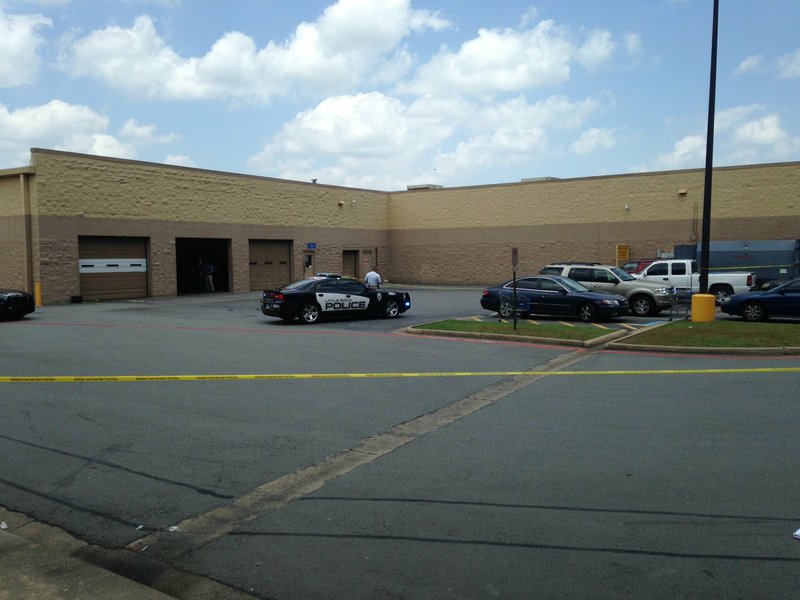 Little Rock police officers investigate Thursday, June 16, 2016, at the scene of shooting behind the Wal-Mart on Baseline Road. 