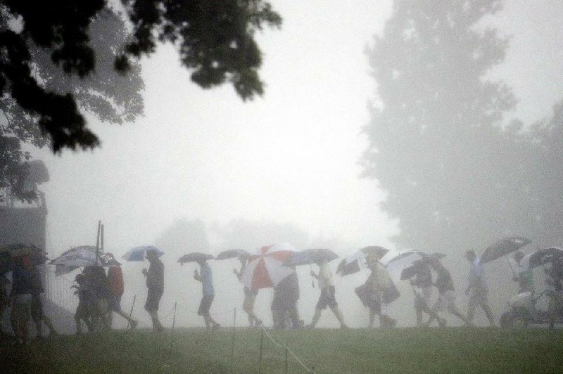 Fans leave the course during the third rain delay in the fi rst round of the U.S. Open on Thursday at Oakmont Country Club in Oakmont, Pa. When the horn blew for the third and what proved to be final time, at 3:51 p.m. local time, nine players had completed their rounds and 78 had yet to tee off. Play is scheduled to resume at 6:30 a.m. Central today.