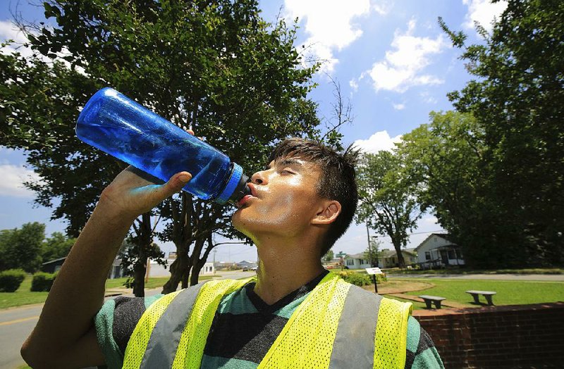 North Little Rock Parks and Recreation Department summer employee Omar Gardner drinks water Thursday afternoon while working at Dark Hollow Memorial Park. The National Weather Service issued its first excessive-heat warning Thursday for central Arkansas. 