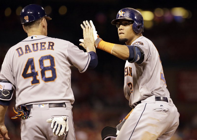 Houston Astros' Carlos Gomez, right, is congratulated by first base coach Rich Dauer after hitting a two-run single during the ninth inning of a baseball game Wednesday, June 15, 2016, in St. Louis. 