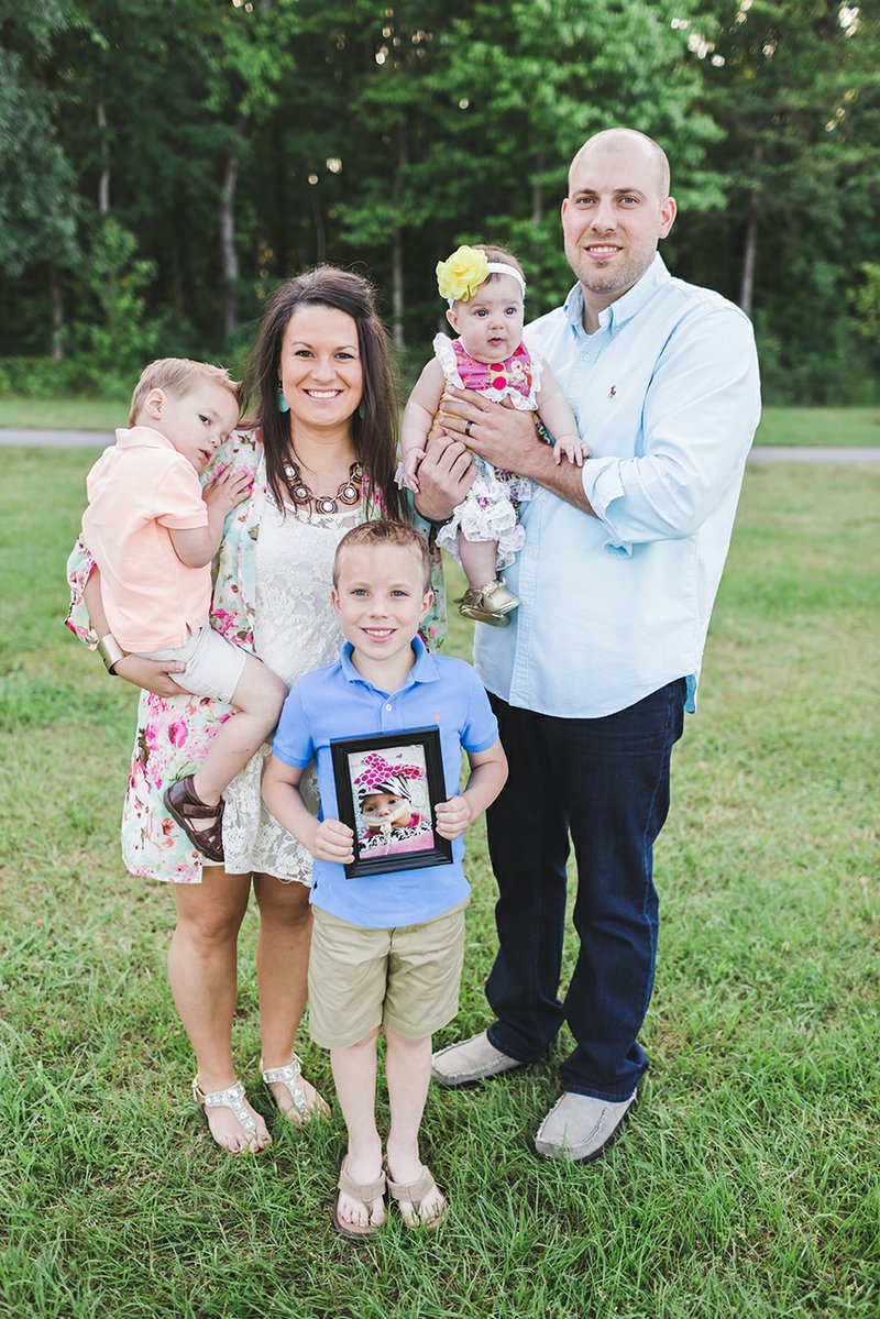 Josh Turner holds his 6-month-old daughter Abbott Reese, and his wife, Crystal, holds their son Reid, 2, who was adopted in October 2013. Jude, 6, holds a picture of Briley Faith, who died 61 days after she was born in 2012. Turner is the Missions and Outreach pastor at Holland Chapel Baptist Church in Benton.