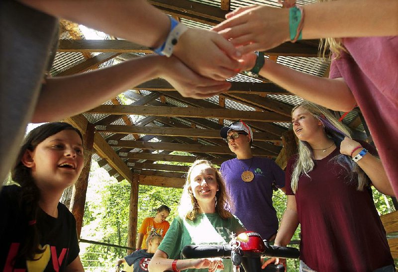 Hailey Fuller (from left), Olivia Fitzgibbon, Sydney Roberts and other Camp Aldersgate campers participate in nature activities with counselor Brittney Green (center background) in a wheelchair-accessible treehouse Thursday. 