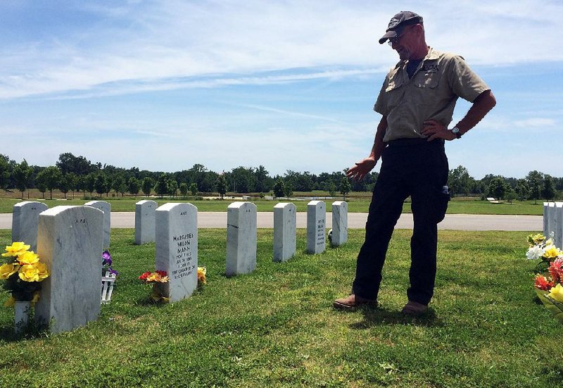 Maintenance supervisor David Ramsey inspects the grass around headstones at the Arkansas State Veterans Cemetery at Birdeye earlier this month. For Ramsey, a former mortar platoon commander who has registered for a grave there, the cemetery’s upkeep is a duty and a privilege.