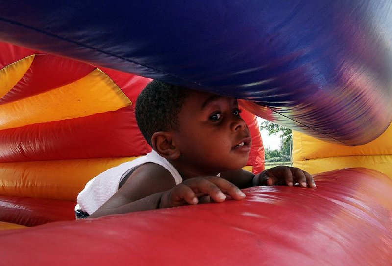 Jayce Jackson, 3, of North Little Rock tries to squeeze his way through a bounce house Saturday during the Mosaic Templars Cultural Center’s Juneteenth celebration in downtown Little Rock. 