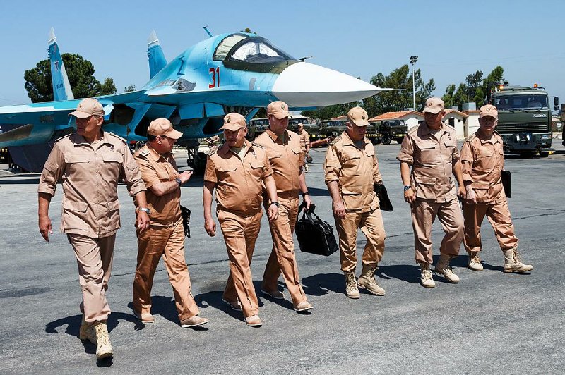 Russian Defense Minister Sergei Shoigu (third from left) visits Hemeimeem air base in Syria on Saturday. He met with pilots and inspected their quarters, a spokesman said.