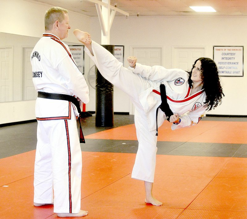MICHAEL WOODS/NWA Democrat-Gazette Cheyanne Burrous, 17, from Siloam Springs, practices her Taekwondo with Master Jerry Lindsey from Impact Martial Arts in Springdale on June 9 as she prepares for her competition in Europe.