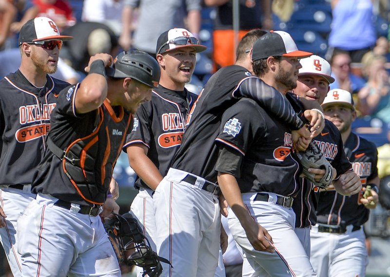 Oklahoma State starting pitcher Thomas Hatch, third from right, is congratulated by teammates after the last out of an NCAA men's College World Series baseball game against UC Santa Barbara in Omaha, Neb., Saturday, June 18, 2016. 