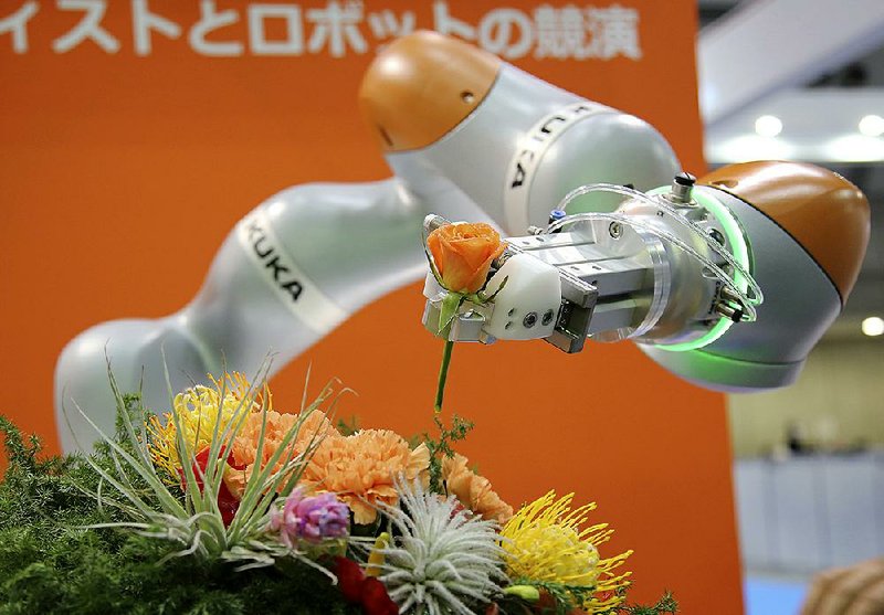 Germany’s Kuka Robotics Co.’s robot LBR iiwa demonstrates flower arranging at the International Robot Exhibition in Tokyo in 2015.