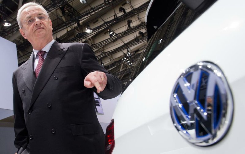 Martin Winterkorn, Volkswagen’s former CEO, stands next to a VW vehicle at the company’s annual shareholder meeting in Hanover, Germany, in this fi le photo. The automaker now faces an investigation into how quickly it reported potential losses to shareholders resulting from the emissions rigging scandal.