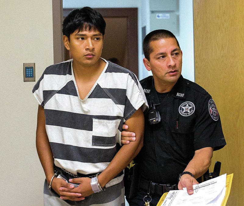 Edward Alexis Martinez-Torres is led Monday from Circuit Judge Robin Green’s courtroom at the Benton County Courthouse in Bentonville. Martinez-Torres, who is accused of killing a 3-month-old boy, had his bond set at $500,000.
