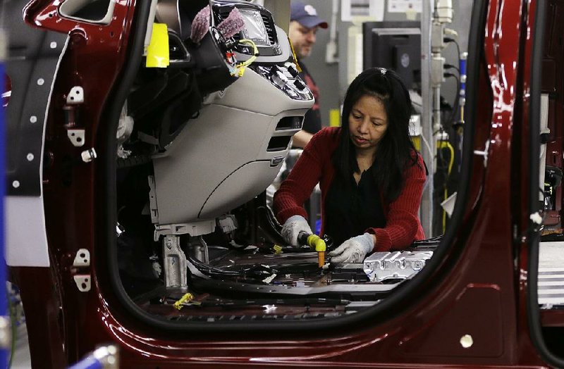 A Fiat Chrysler employee works on a 2017 Chrysler Pacifica at the Windsor, Ontario, assembly plant in May. Fiat Chrysler will stop using Takata air bag inflators that don’t have a drying agent in global production in September. 