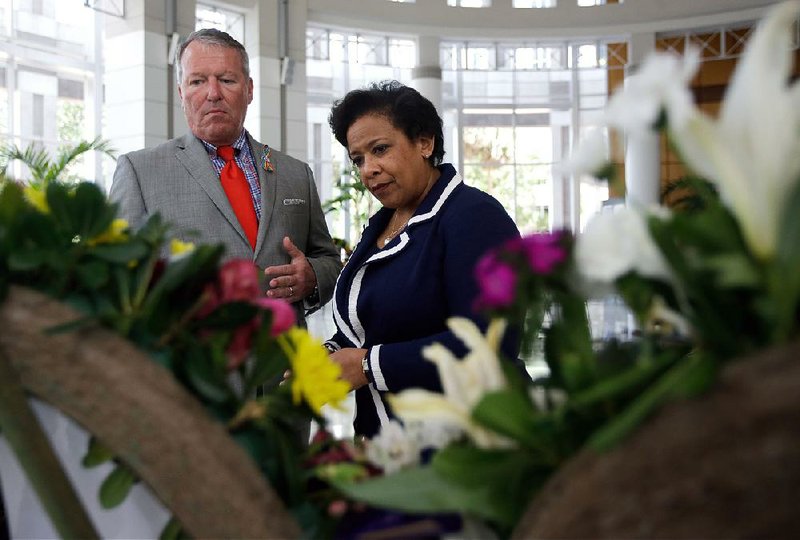 Orlando Mayor Buddy Dyer (left) and U.S. Attorney General Loretta Lynch view a memorial at City Hall of 49 wreaths, one for each victim of the Pulse nightclub shooting, on Tuesday in Orlando, Fla. 