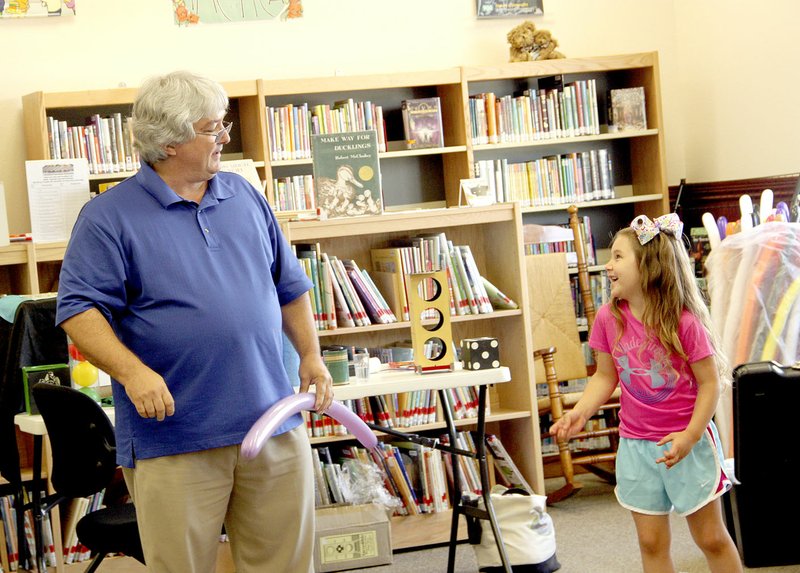 LYNN KUTTER ENTERPRISE-LEADER Marty Boone with Balloon Magic of Greenbriar teases Rahely Floyd, 5, of Farmington as she tries to remember the steps to make a balloon figure. Boone entertained children last week at Farmington Public Library with magic tricks and fancy balloon art.