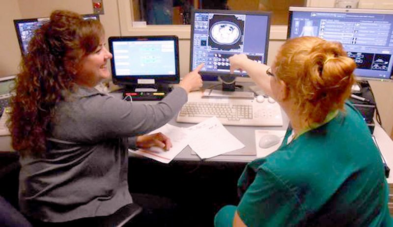 Photo submitted Stephanie Mazey, left, provided training to Julie Pederson, right, in the Siloam Springs Regional Hospital Imaging Department for the upgraded CT software.
