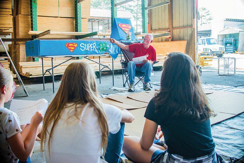 Larry Jernigan shows a boat he built and raced in the World Championship Cardboard Boat Races as an example of how to construct a cardboard boat during the How to Build a Cardboard Boat workshop at the F.L. Davis Ace Home Center in Heber Springs on June 15. The Heber Springs Area Chamber of Commerce will present another workshop from 5:30-7:30 p.m. June 29 at Quality Floorz & Supply to help teams create sturdy boats for the 
World Championship Cardboard Boat Races on July 30.