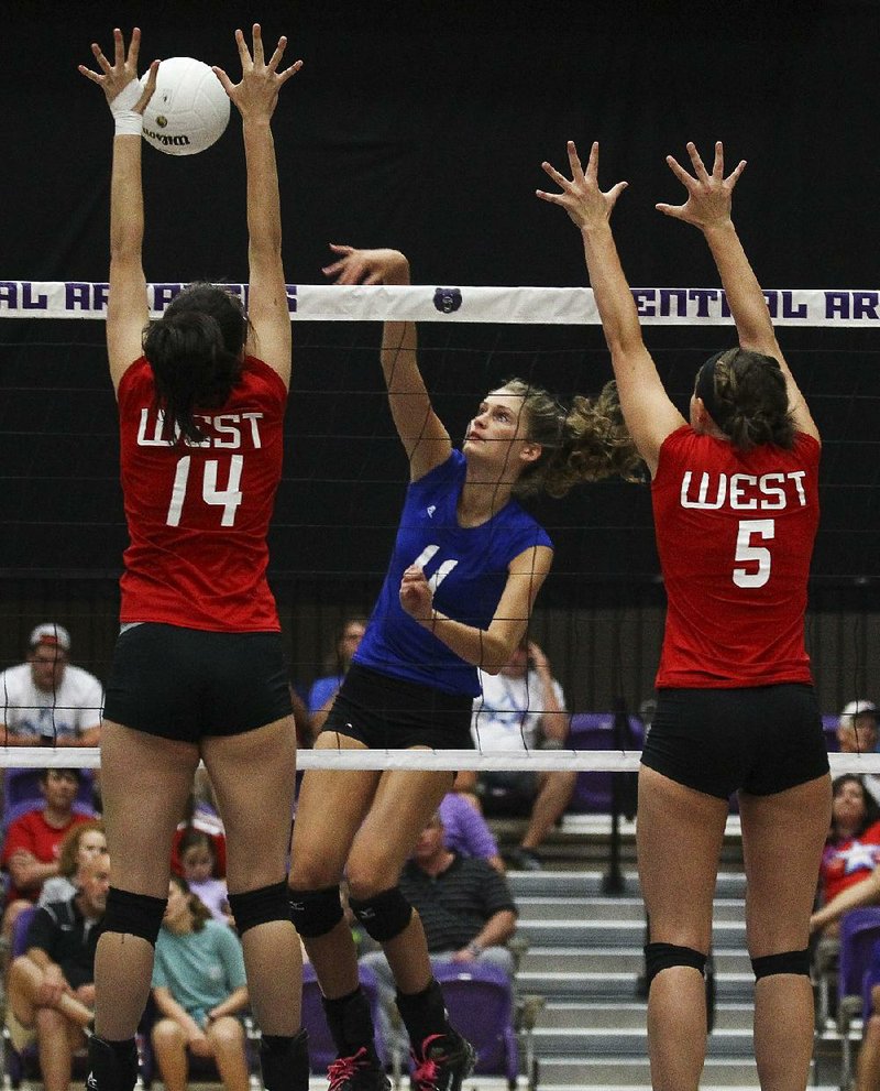 The East’s Allie Anderson (center) of Bryant hits over the West’s Greer Rogers (14) of Fort Smith Southside and Pearl Lee of Fountain Lake during the All-Star volleyball game in Conway on Wednesday night. The East won 3-2.