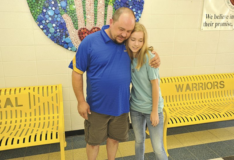 Raegan Couch gets a hug from Brian Watt, band director of Central Junior High in Springdale. Raegan cut her hair this spring and donated it to Pantene’s Beautiful Lengths program, which uses donated hair to make wigs for women who have lost their hair due to cancer. Raegan donated the hair in the name of Nancy Watt, Brian Watt’s mother, who just finished 18 weeks of chemotherapy.