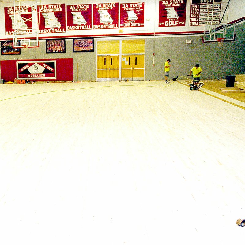 Photo by Rick Peck Workers install tongue-and-groove flooring for a new floor in the main gym at McDonald County High School as one of the facility improvements being done over the summer. The original floor itself had been replaced once since it was installed in 1965, but this is the first time the subfloor was removed and replaced.