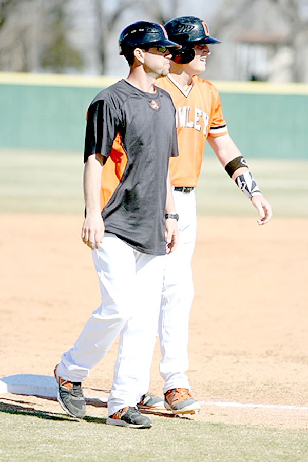 Brock Buckingham talks to a runner while coaching third base during a game earlier this season at Cowley College. Photo Courtesy of Rama Peroo