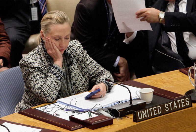 In this March 12, 2012 file photo, then-Secretary of State Hillary Rodham Clinton checks her mobile phone after her address to the Security Council at United Nations headquarters. 