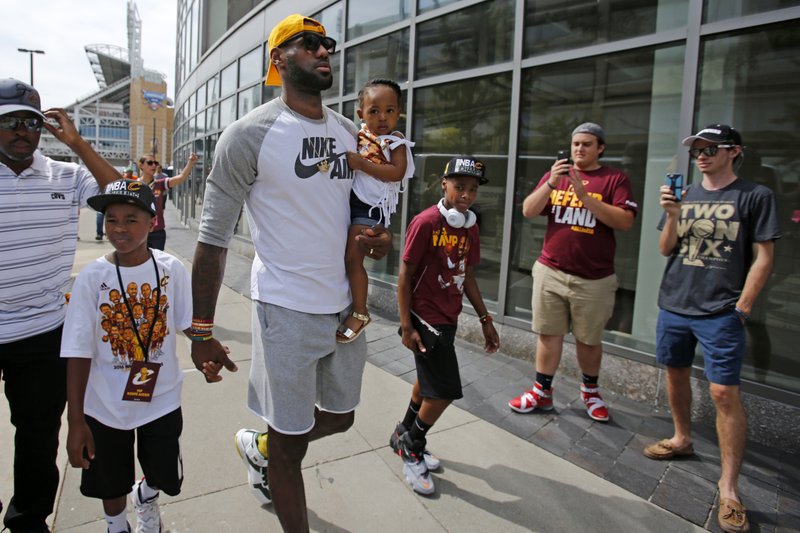 The Associated Press CLEVELAND ROCKS: Cleveland Cavaliers' LeBron James, center, arrives at the Quicken Loans Arena with his children before a parade celebrating the Cavaliers' NBA Championship Wednesday in downtown Cleveland. The Cavaliers made history by overcoming a 3-1 deficit to beat the Golden State Warriors in the NBA Finals and end the city's 52-year drought without a professional sports championship.