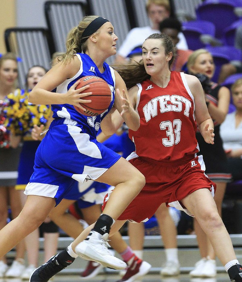 Logan Oestreich of the East team drives to the basket past Ally Teague of the West team during the East’s 92-72 victory over the West on Thursday at the state high school All-Star Game in Conway. 