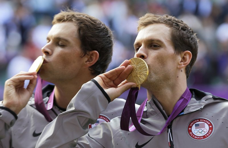 In this Aug. 4, 2012, file photo, Mike Bryan, right, and Bob Bryan, left, of the United States, kiss their gold medals after the medal ceremony of the men's doubles final match at the 2012 Summer Olympics at the All England Lawn Tennis Club at Wimbledon, London. 