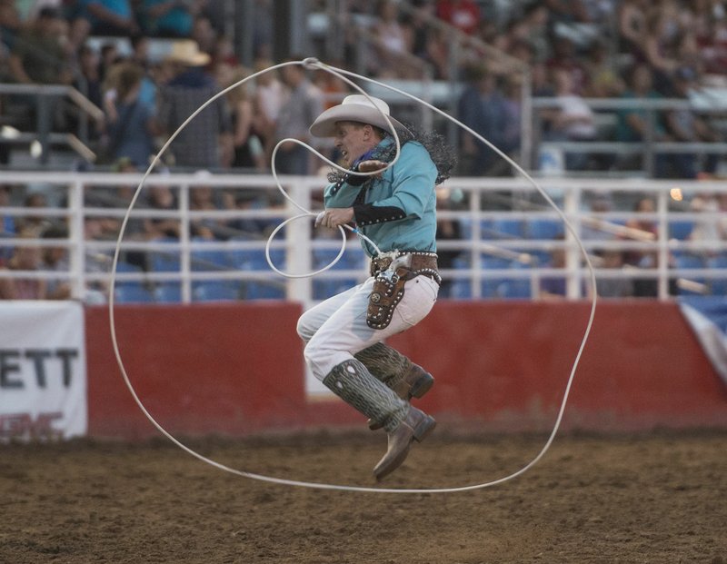 Rider Kiesner, a trick roper from Ridley, Okla., jumps through a lasso during Wednesday’s performance at the Rodeo of the Ozarks at Parsons Stadium in Springdale. He explained he relies on centrifugal force for his roping tricks.