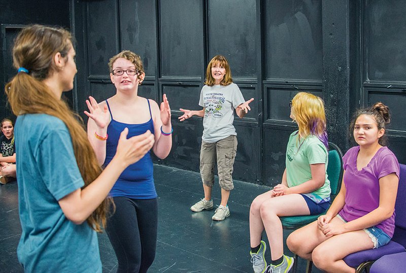 From left, Ashleigh Plasters, left, assistant to the Youth Theatre of Central Arkansas Summer Intensive Program junior group, talks to Madison Brown, 12, as Ruthann Curry Brown, director of the program, talks to Kwynn McEntire, 13, and Juliana Breshears, 12. The students were rehearsing a play they will perform for the public at 7 p.m. July 14-15 and 2 p.m. July 16 in the Bridges/Larson Theatre inside the Snow Fine Arts Center at the University of Central Arkansas.