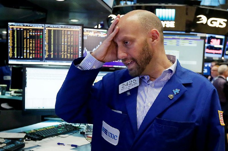 Specialist Meric Greenbaum works Friday on the floor of the New York Stock Exchange, where rattled traders got rid of riskier assets. 