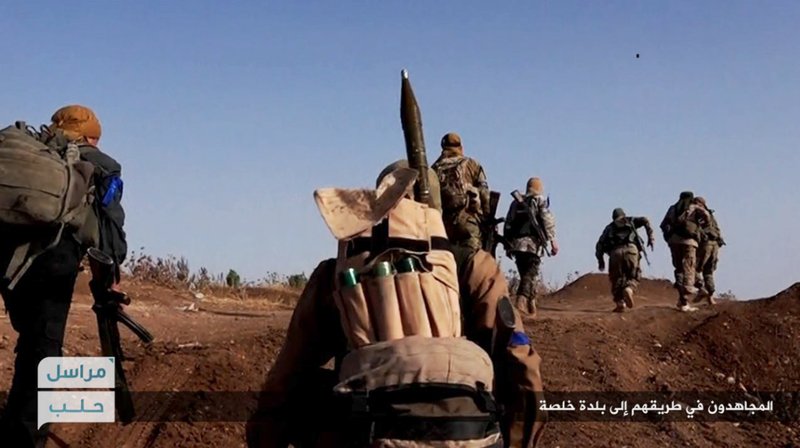 This file image posted on the Twitter page of Syria's al-Qaida-linked Nusra Front on Tuesday, June 14, 2016, which is consistent with AP reporting, shows Nusra Front fighters moving forward to fight against Syrian troops and pro-government gunmen at the hilltop of Khalsa village, southern Aleppo, Syria. 