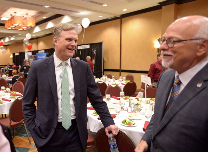 Joseph Steinmetz (right), University of Arkansas chancellor, chats with Nat Lea, CEO of WEHCO Media, Inc. and incoming president of the Arkansas Press Association, Friday during the Arkansas Press Association SuperConvention at the DoubleTree Suites by Hilton in Bentonville. 