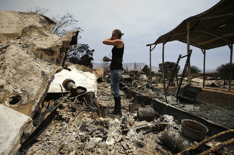 Amy Nelson breaks down Saturday as she goes through the remains of her home destroyed by a wildfire in South Lake, Calif.