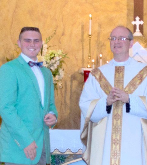 Submitted photo Sam Tankersley, left, a 2016 graduate of St. John's Catholic School, recently received the SJS Writing Achievement Award. He is an avid reader and now a published author. Tankersley was congratulated by Pastor James West.