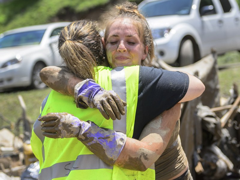 Taylor Self hugs a woman who traveled from Parkersburg with the Sunrise Baptist Church disaster relief team, before going back into Sherry Cole’s home to help clean up in Clendenin, W.Va., on Saturday. Church groups and other organizations from all over the state sent multiple people to Clendenin to help feed residents and salvage items from homes. 