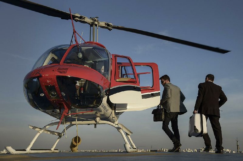 An employee helps a passenger load luggage into an Uber Technologies Inc. UberCOPTER at the Blue Tree Hotel helipad in Sao Paulo in mid-June.