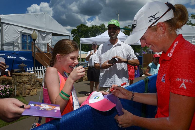 Former Arkansas All American Stacy Lewis signs an autograph for Haylee Lantz, 10, of Bella Vista on Sunday during the final round of the Wal-Mart LPGA NW Arkansas Championship at Pinnacle Country Club in Rogers. Lewis, who also handed out Arkansas Razorbacks footballs to fans, shot a fi nal-round 68 and finished nine shots off the lead at 8-under-par 205.