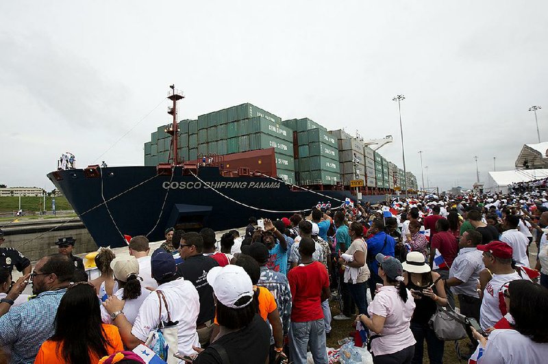 Spectators watch as the cargo ship Cosco Shipping Panama, carrying more than 9,000 containers, begins to cross the new Agua Clara locks near the port city of Colon, Panama, on Sunday.