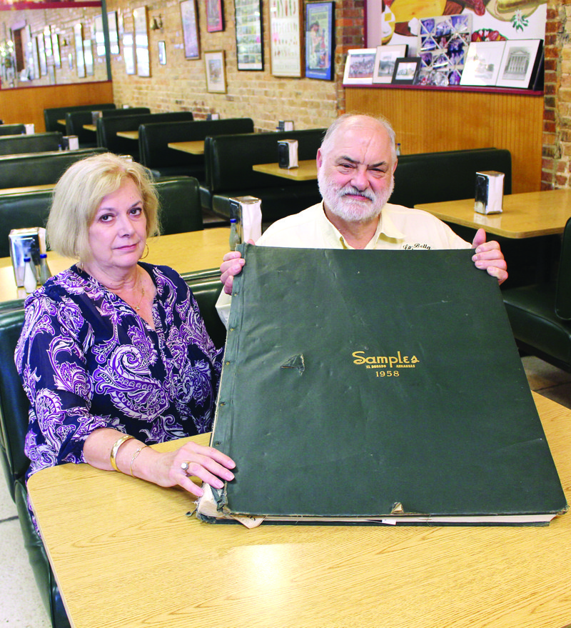 Beth and Jim Robinson, co-owners of La Bella Gourmet Gifts & Delicatessen, display the 1958 Samples scrapbook.