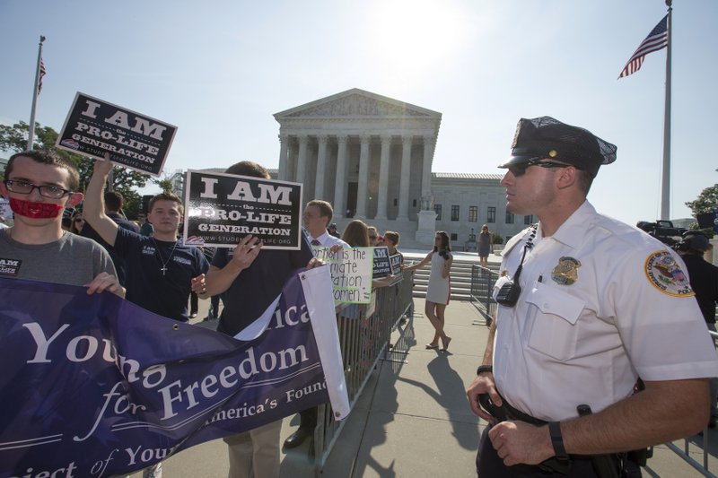 Activists demonstrate in front of the Supreme Court in Washington, Monday, June 27, 2016, as the justices close out the term with decisions on abortion, guns, and public corruption are expected. (AP Photo/J. Scott Applewhite)
