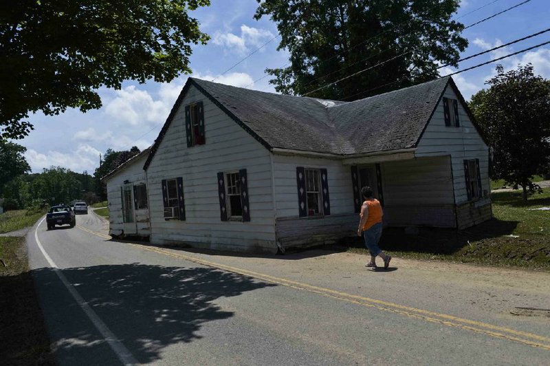 A home carried by flash-flood waters sits in the middle of a road in Rupert, W.Va., on Sunday.
