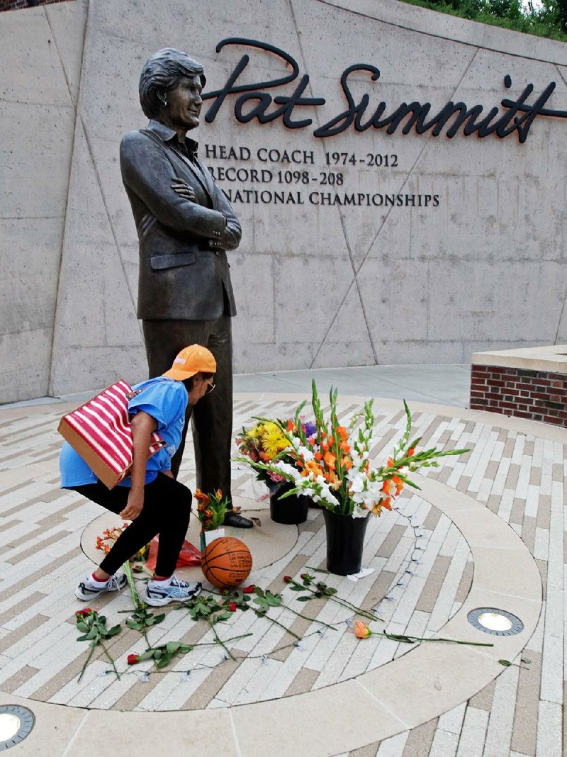 Tennessee women’s basketball fan Fran Swanson lays flowers at the statue of former Lady Volunteers coach Pat Summitt in Knoxville, Tenn. Summitt died Tuesday morning.