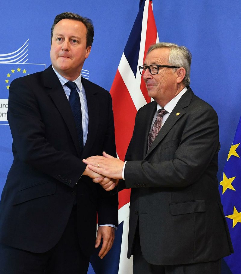 British Prime Minister David Cameron (left) talks with European Commission President Jean-Claude Juncker at EU headquarters in Brussels on Tuesday. 