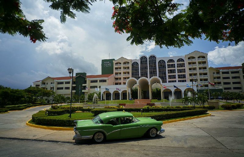 A vintage car passes in front of the Four Points by Sheraton hotel in Havana on Tuesday. American hotel giant Starwood has begun managing the hotel, owned by the Cuban military. 